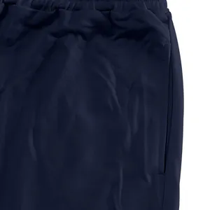 Close-up view of navy blue sports joggers showing fabric texture and side pocket detail