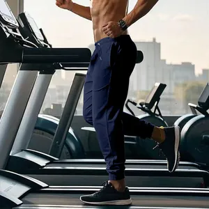 Close-up view of navy blue men's joggers showing drawstring waist and elastic cuffs in gym