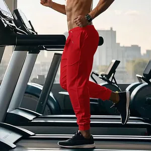 Red men's athletic joggers showing breathable fabric and tapered fit in gym environment