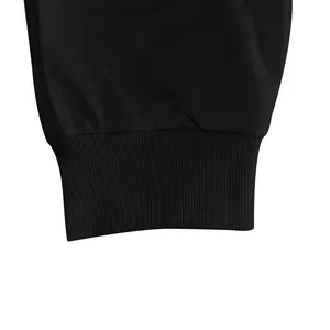Detailopname van de elastische geribbelde boord van een zwarte heren joggingbroek.
