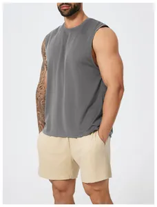 Detail view of men's grey quick-dry tank top and beige mesh sports shorts.
