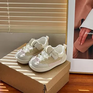 Primer plano de zapatillas transpirables de malla para bebés en beige y rosa