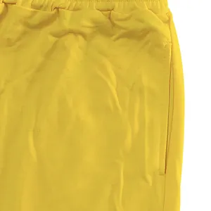 Close-up detail of yellow French Terry sports joggers showing fabric texture and side pocket