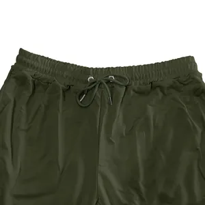 Close-up view of the elastic drawstring waistband on men's olive green sweatpants