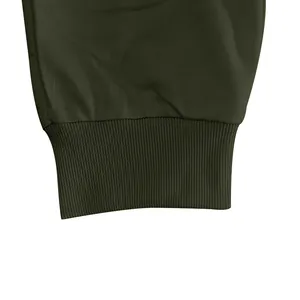 Close-up van de olijfgroene geribbelde manchet van een losse heren joggingbroek