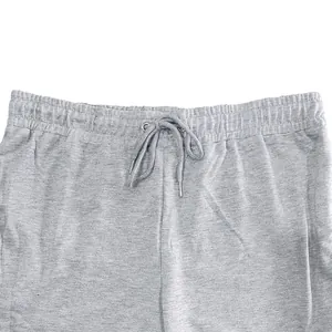 Close-up detail of grey men's jogger sweatpants featuring elastic waistband and drawstring