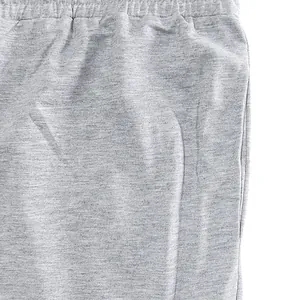 Close-up detail of gray cotton joggers featuring elastic waistband and side pocket