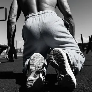 Detailopname van grijze heren sportbroek met elastische taille op de atletiekbaan