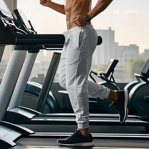 Action shot of men's gray slim-fit training joggers on a treadmill in a gym