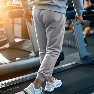 Detail van grijze heren sportbroek met trekkoord in de sportschool op een loopband-opname.