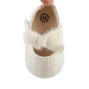 Detailansicht von Baby-Prinzessin-Schuhen mit großer Plüschschleife und Webstruktur