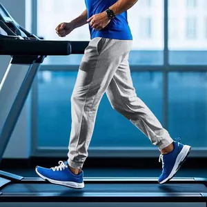 Action detail of men's grey sports joggers worn during a treadmill workout in gym
