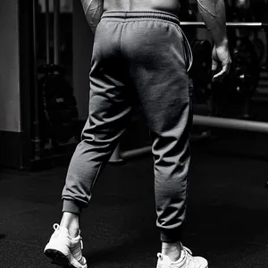 Gedetailleerd achteraanzicht van grijze joggingbroek voor heren in een sportschool