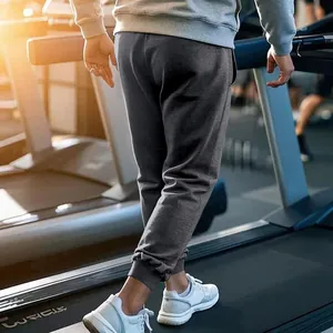 Losse donkergrijze joggingbroek voor heren in een sportschool voor fitness en vrije tijd