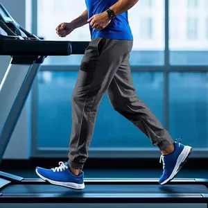 Action shot of men's dark grey jogging sweatpants on a running treadmill