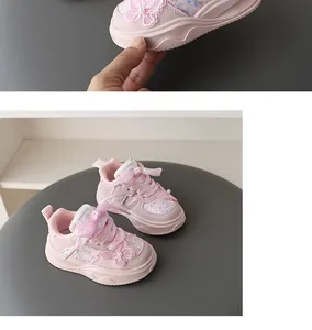 Detalle de zapatillas rosa para niña con aplique de mariposa y adornos de lentejuelas brillantes