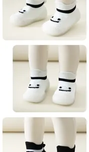 Gros plan sur les chaussures de marche respirantes blanches pour bébé avec visage souriant.
