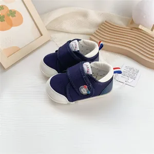 Primer plano de zapatos de bebé azul marino con punta de goma blanca y cierre de velcro