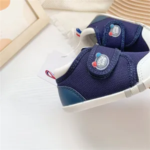 Vista detallada de zapatos para bebés en azul marino con suelas blandas y cierre de velcro