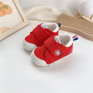 Detalle de zapatos rojos para bebé con cierre de velcro y suela blanda para caminar.