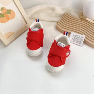 Vista detallada de zapatos para primeros pasos de bebé rojos y blancos con velcro
