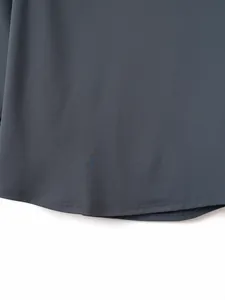 Close-up detail of the smooth hemline on a dark grey long-sleeve polo shirt for men.