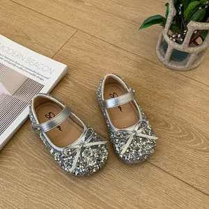 Detailed view of sparkling silver sequin girls' princess shoes with elegant bow