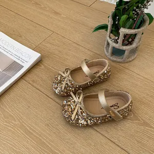 Detailed macro view of shimmering gold glitter girls' princess shoes with elegant bow accent