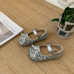 Close-up of silver sequin girls' princess shoes featuring a bow and metallic silver strap
