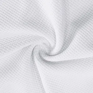 Dettaglio macro del tessuto a maglia nido d'ape bianco con trama traspirante.