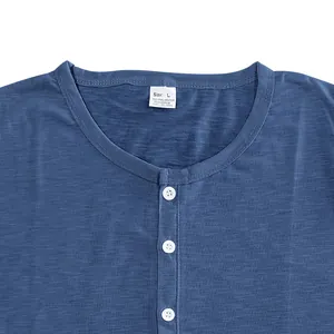 Close-up of blue slub cotton Henley T-shirt neckline with buttons and size tag.