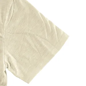 Close-up detail of slub cotton fabric and double-stitched sleeve on beige t-shirt