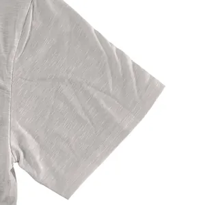 Close-up detail of slub cotton t-shirt sleeve showing texture and double-stitched hem finish.