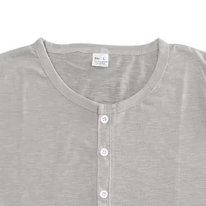 Macro view of grey slub cotton Henley shirt collar and white button detail