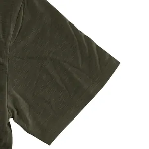 Close-up detail of the slub cotton sleeve and stitching on the olive green Henley shirt