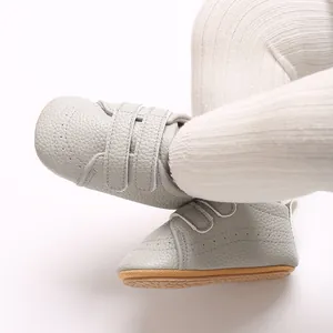 Dettaglio scarpe neonato grigie stile inglese con suola in gomma antiscivolo e chiusura a strappo