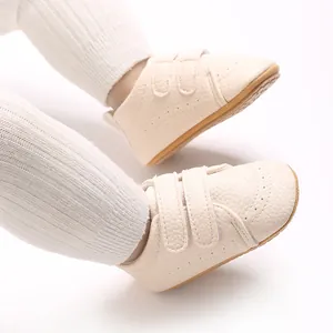 Vista ravvicinata di scarpine primi passi beige per neonati con suola antiscivolo e velcro