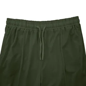 Detalle de la cintura elástica y el cordón en los pantalones de chándal verdes