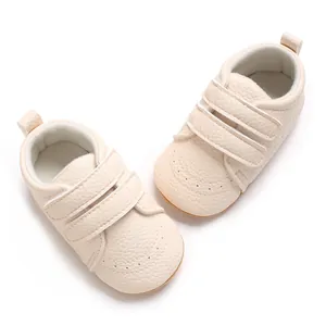 Primo piano di scarpine per neonati color crema con velcro e suola antiscivolo morbida
