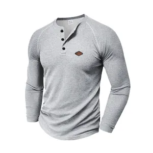 Dettaglio di una maglia Henley grigia in maglia a nido d'ape da uomo con maniche a raglan.