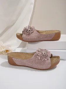 Vue détaillée des sandales à plateforme roses avec décorations florales élégantes