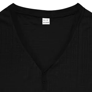 Detail of black Henley shirt neckline showing buttons and linen-like fabric texture