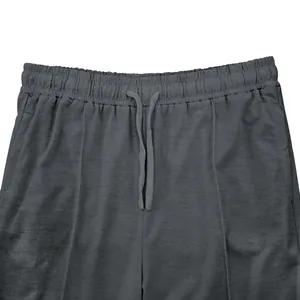 Primer plano de la cintura elástica y cordones ajustables de un pantalón deportivo gris