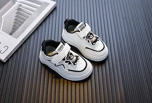 Perspectiefzicht van witte peutersneakers met schattige beer decoratie en klittenband sluiting
