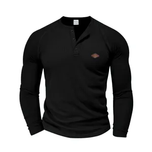 Primo piano del tessuto a nido d'ape nero e dettaglio del collo Henley con bottoni per uomo