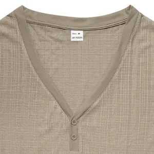 Detailed macro shot of a khaki Henley shirt collar showing breathable slub linen texture