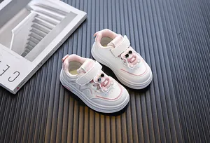 Detailweergave van witte peutersneakers met een schattig beerontwerp en roze accenten