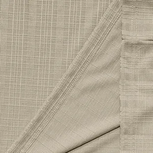 Close-up van beige imitatie linnen textuur stof met gedetailleerd weefsel en naad