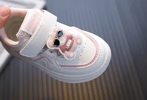 Detailopname van een witte peutersneaker met een schattige beer en roze accenten