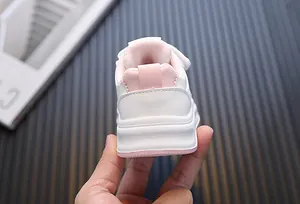 Detail van de achterkant van wit-roze loopgympen voor peuters met hiellus accent